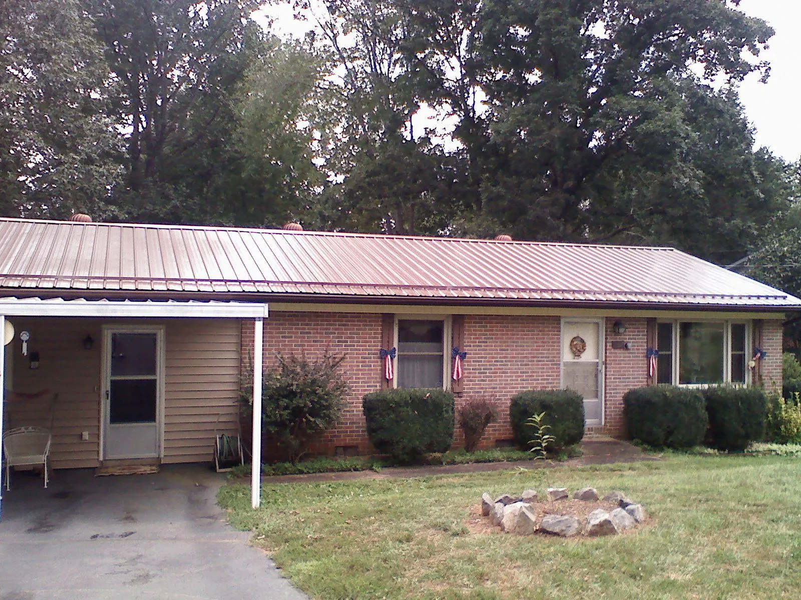 Bronze metal roof and carport on a brick ranch home — Roof Repair work by our crew in Gold Beach